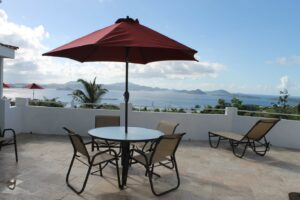 A table and chairs with an umbrella on the patio.